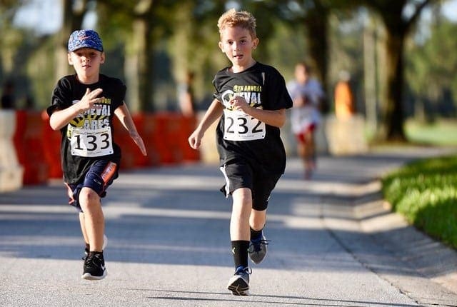 Two young boys are competing in the Cheval Cares 5K in Lutz Florida as they are running fast towards the finish line